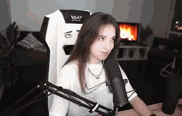 a young woman is sitting in a chair in front of a microphone .