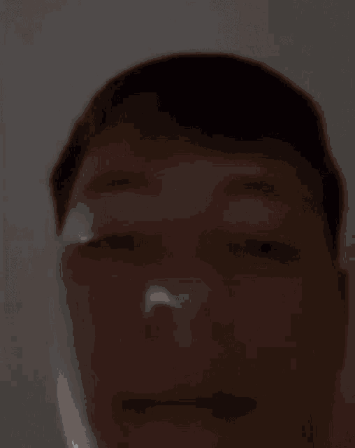 a close up of a person 's face with their eyes closed in the dark .