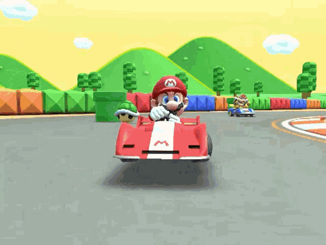 mario is driving a red race car with the letter m on the front