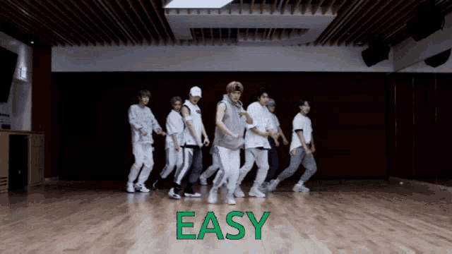 a group of young men are dancing in a room with the word easy written on the floor