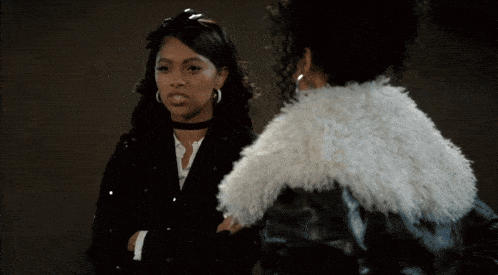 two women standing next to each other one wearing a fur coat