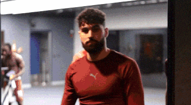 a man in a red puma shirt stands in a gym