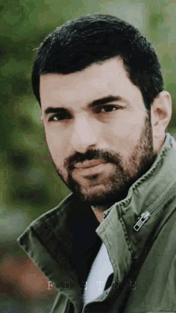 a man with a beard is wearing a green jacket with the word fortune on the bottom