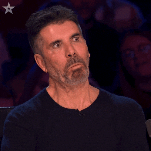 a man with a beard is sitting in front of a crowd with a star in the background