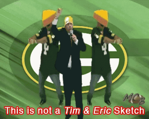 a green bay packers logo is behind a man in a suit
