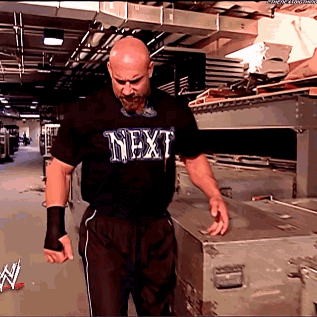 a man wearing a black shirt that says next on it