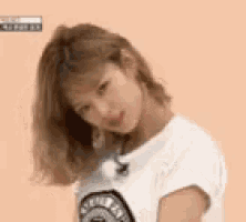 a woman in a white t-shirt is looking at the camera .