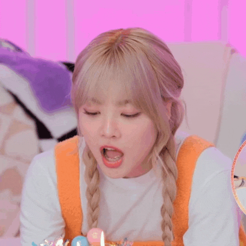 a girl blowing out candles on a birthday cake with chinese characters on the bottom