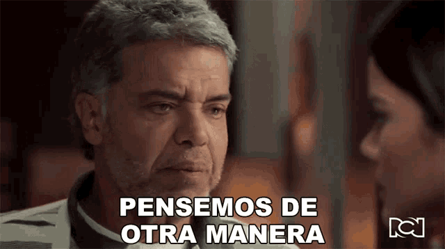 a man with a beard says pensemos de otra manera in front of a woman