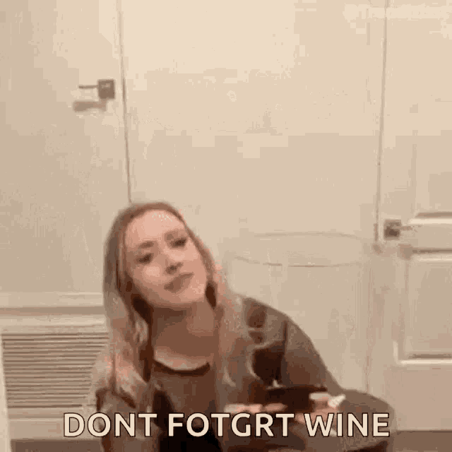 a woman is sitting on the floor with a glass of wine in her hand and says `` dont fotgrt wine '' .