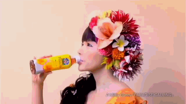 a woman with flowers in her hair drinking from a bottle that says milky bunny paradise calling
