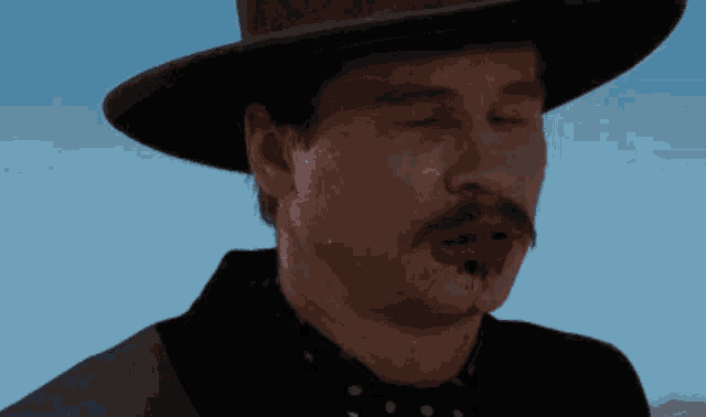 a man wearing a hat has blood on his face