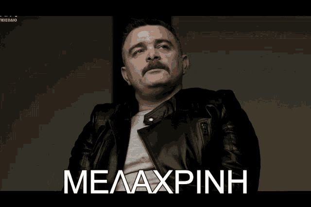 a man with a mustache is wearing a black leather jacket and says byzi toympano in white letters