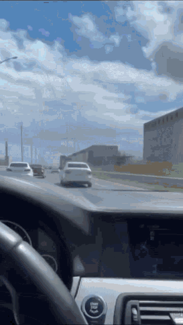 a car is driving down a highway and the dashboard has a button that says start