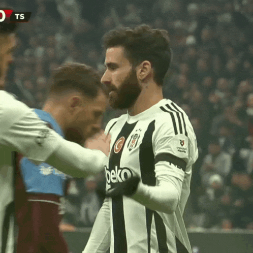 a soccer player wearing a beko jersey hugs another player