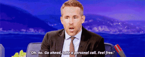 a man in a suit and tie is sitting in front of a microphone on a television show .