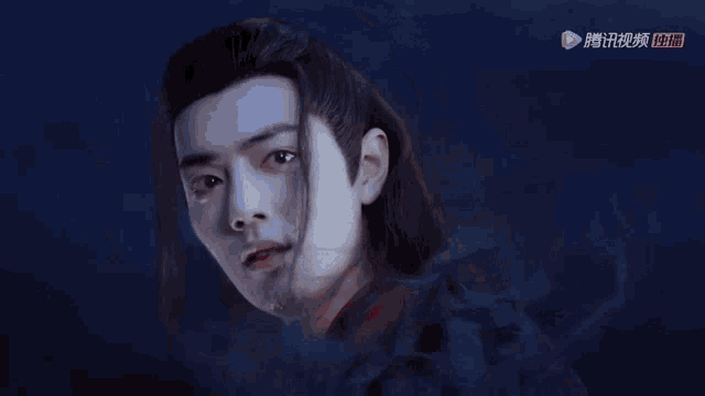 a close up of a man 's face with chinese writing on it