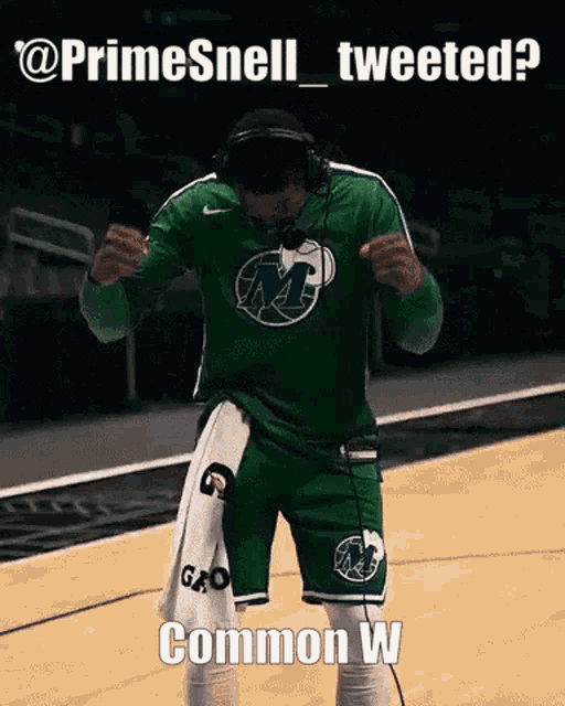 a basketball player wearing headphones and a green jersey with gatorade on the shorts