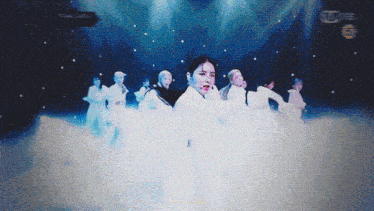 a group of women are dancing on a stage with the number 6 on the bottom right