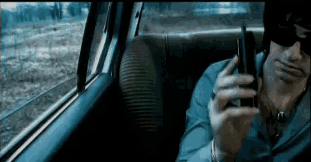 a man wearing sunglasses is talking on a cell phone
