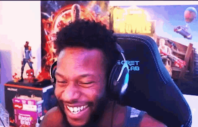 a man is wearing headphones and smiling while sitting in a chair .