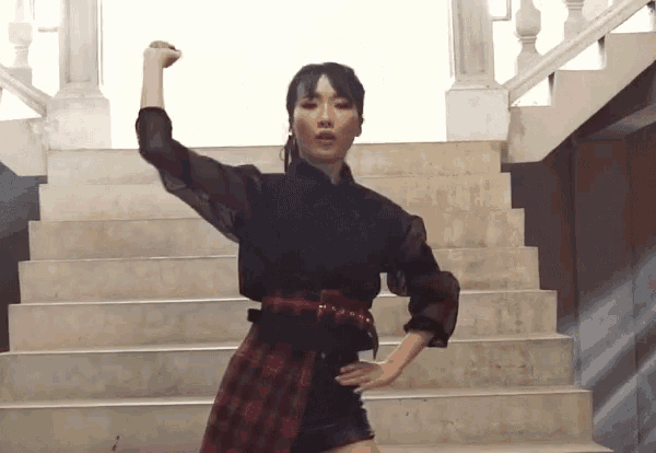 a woman stands on a set of stairs with her fist up