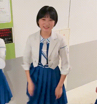 a girl wearing a blue dress and a white jacket is smiling