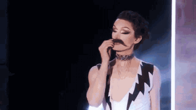 a woman with a fake mustache is wearing a lightning bolt necklace .