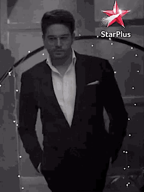 a man in a suit stands in front of a starplus logo