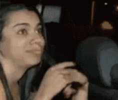 a woman is sitting in a car looking at something