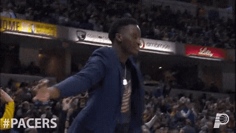 a man in a suit stands in front of a crowd with his arms outstretched and #pacers written on the bottom