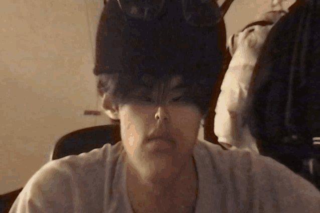 a person 's head is visible in a blurry photo with a white shirt on