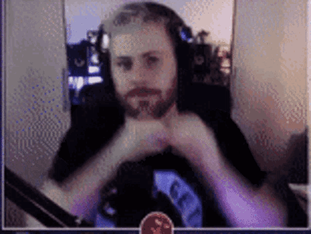 a man with a beard is wearing headphones and a shirt that says ' get ' on it