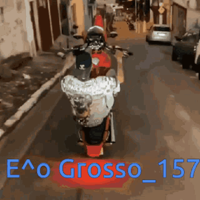 a man is riding a motorcycle down a street with the words e ^ o grosso 157 written on the bottom