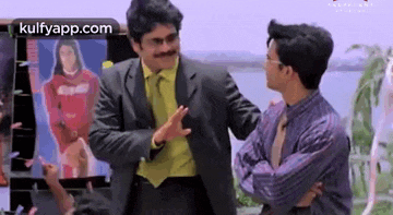 a man in a suit and tie is dancing with another man .