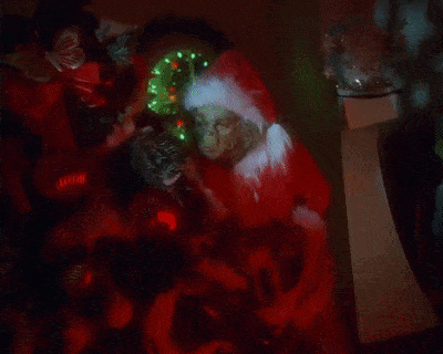 a man in a santa hat is holding a christmas wreath in his hands .