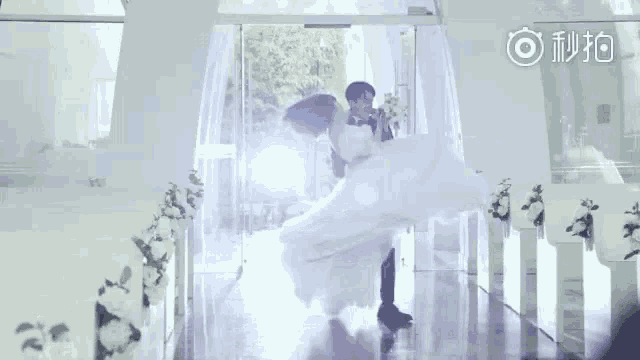 a bride and groom are walking down a aisle at their wedding .