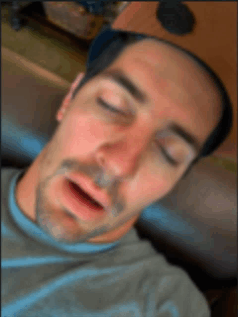 a man is sleeping with his eyes closed and his mouth wide open