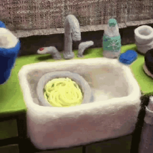a sink with a bowl of yellow soap in it