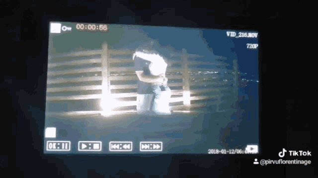 a screen shows a video of a man and woman hugging with the time of 00:00:55