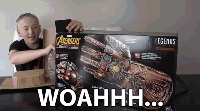 a boy holds up a marvel legends infinity gauntlet