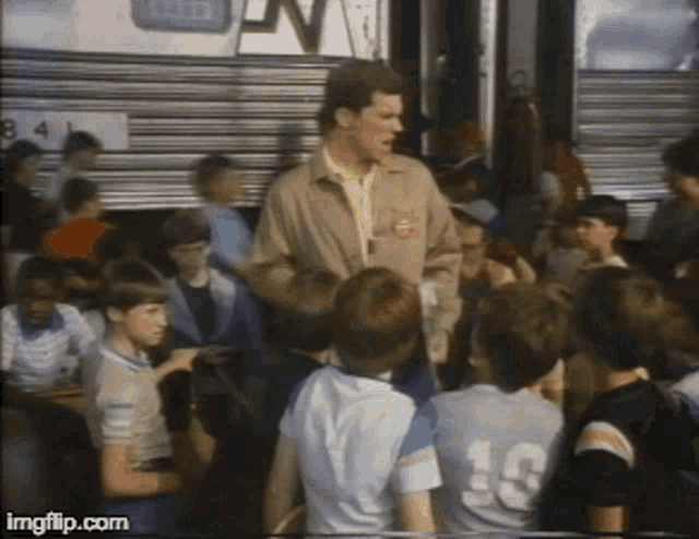 a man is talking to a group of children including one wearing a number 10 jersey