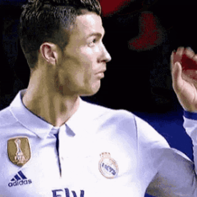 a soccer player wearing a white shirt with the word adidas on the front