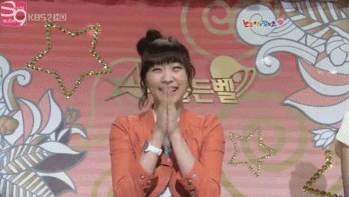 a woman is smiling in front of a kbs 2 hd sign