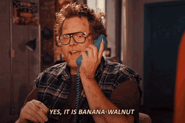 a man talking on a phone with the words yes it is banana-walnut written below him