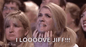 a woman is crying in a crowd of people while sitting in a stadium .