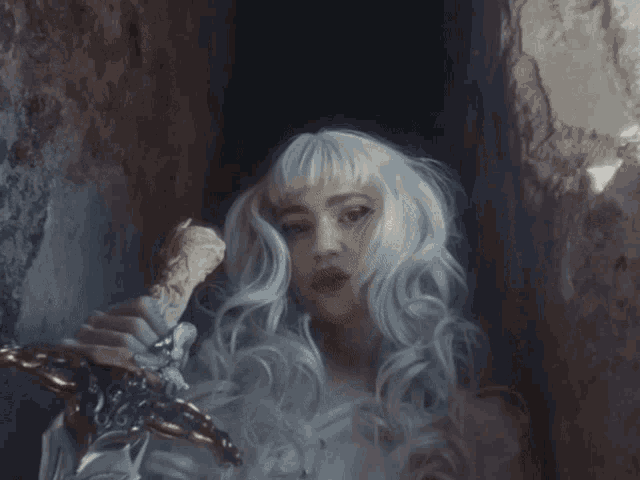 a woman with white hair is holding a sword in her hand