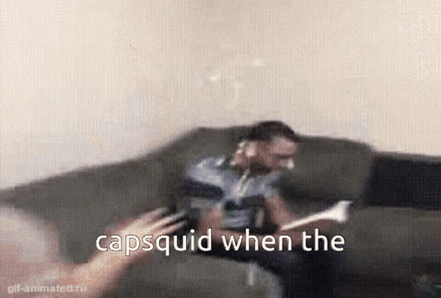 a man is sitting on a couch with the words capsquid when the written in the corner