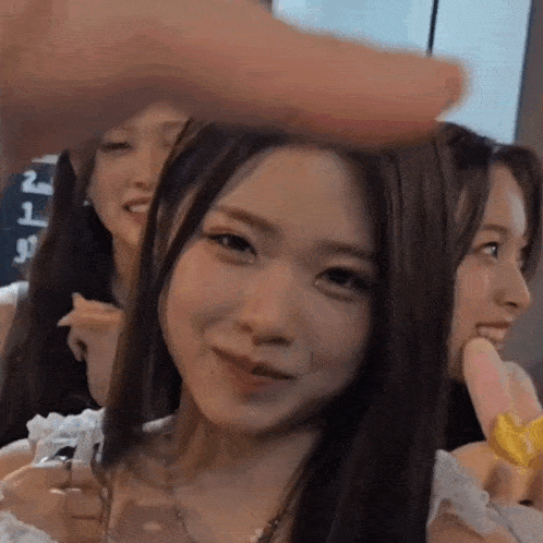 a group of young women are standing next to each other and one of them is smiling .