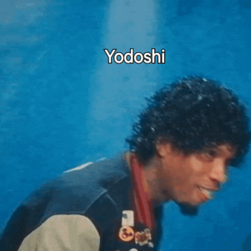 a man with curly hair is wearing a varsity jacket with the letter r on the sleeve